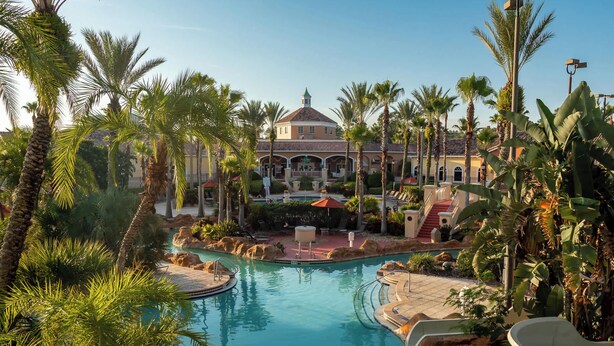 Un resort con piscina, palmeras y un edificio con cúpula.