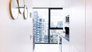Eine moderne Küche mit Stadtblick, minimalistisches Design und ein großes Fenster.