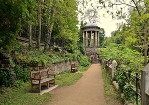 A pathway leading to a stone structure with columns, surrounded by greenery and benches. - Chic City Hideaway - Cozy, Central & Quiet - Pass the Keys (Edinburgh)