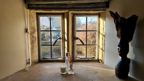 A room with a large window, a sculpture, and a candle. - 18th Century Cotswolds Cottage | Parking | Garden - Pass the Keys (Bourton-on-the-Water)
