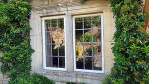 A stone building with a window featuring a grid pattern. - 18th Century Cotswolds Cottage | Parking | Garden - Pass the Keys (Bourton-on-the-Water)