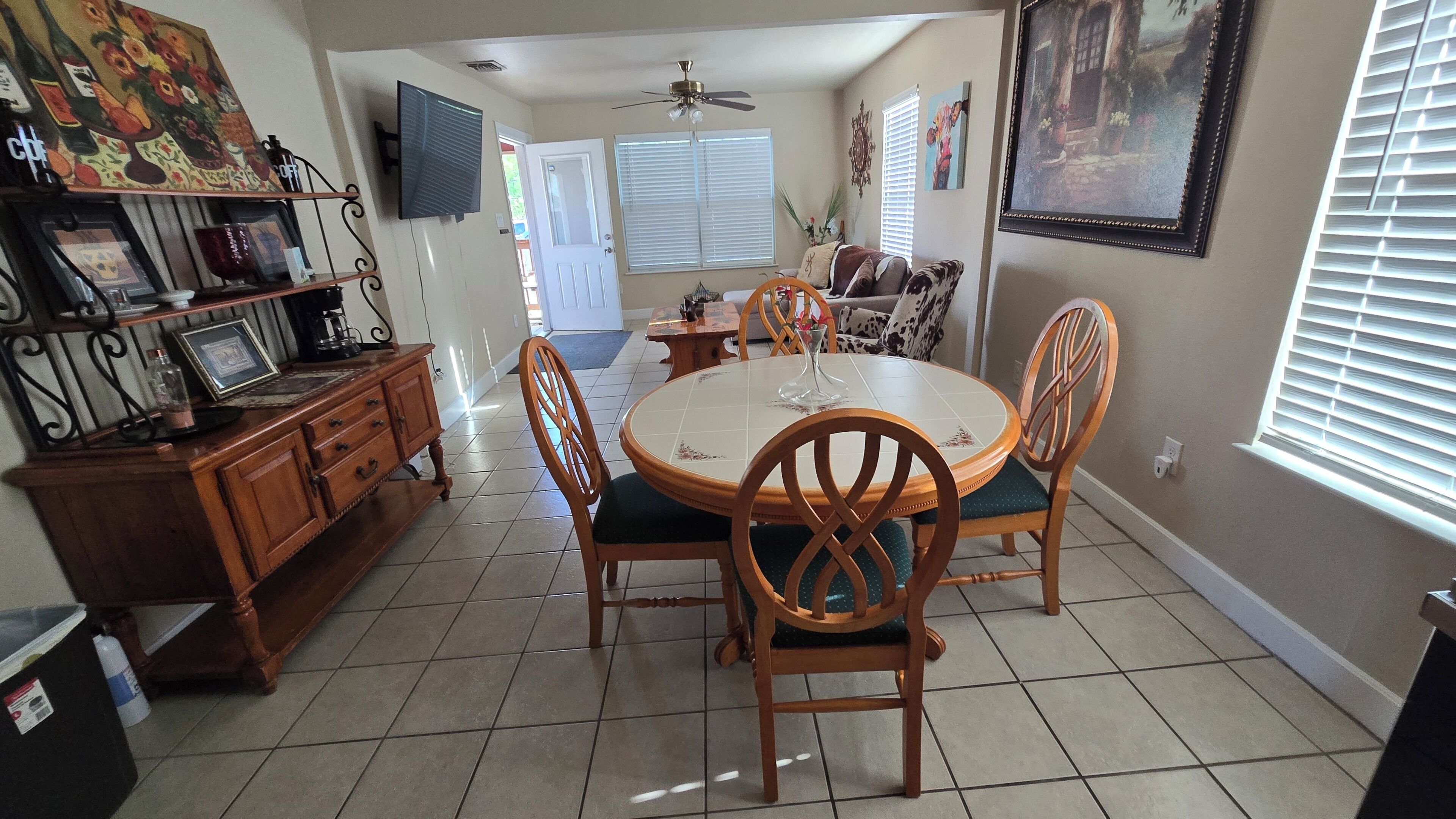 A dining area with a round table, chairs, and a coffee station.