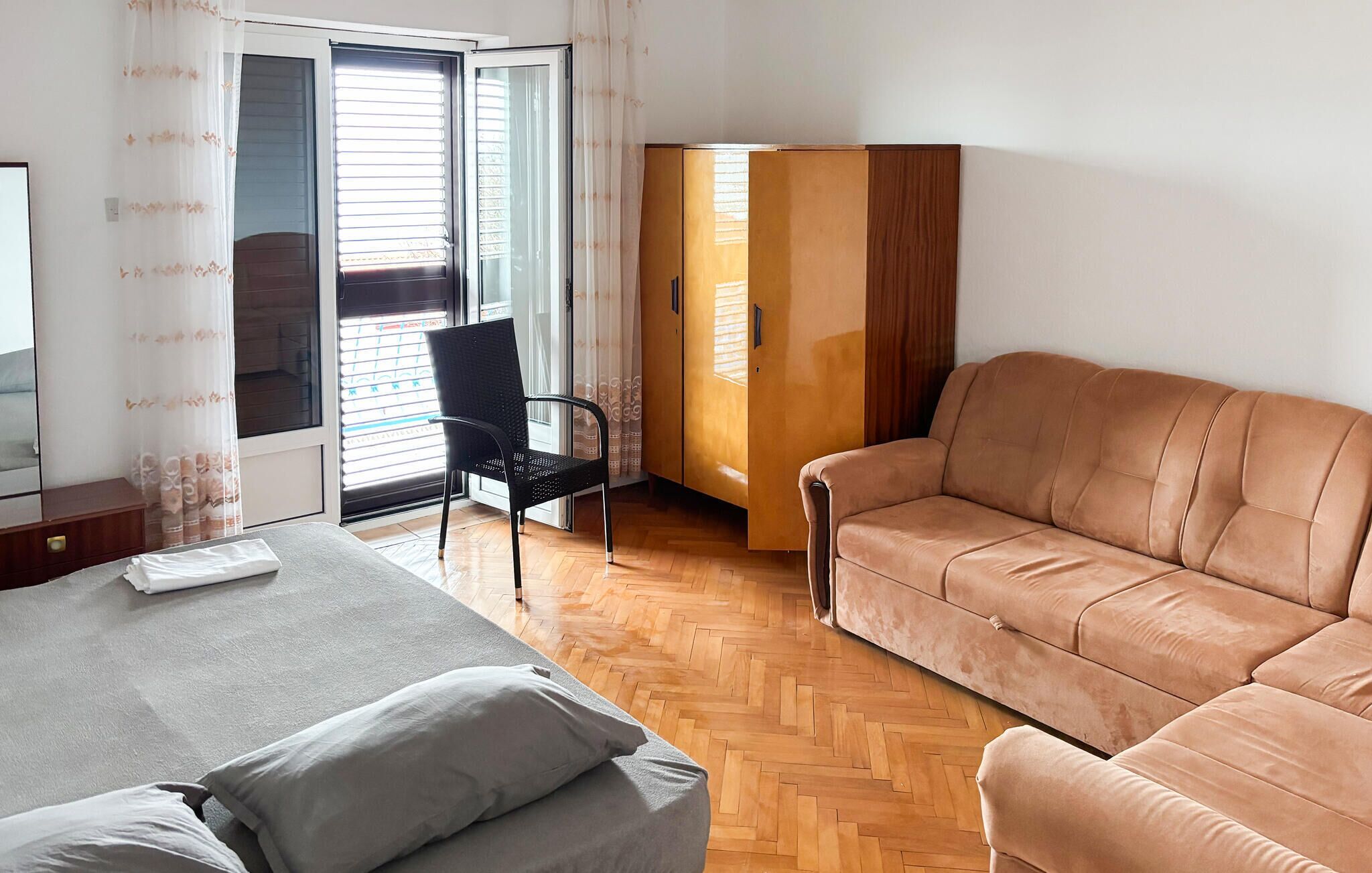 Quarto com cama, sofá, cadeira e guarda-roupa.