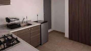 A modern kitchen with a gas stove, a dishwasher, a sink, and a cabinet.