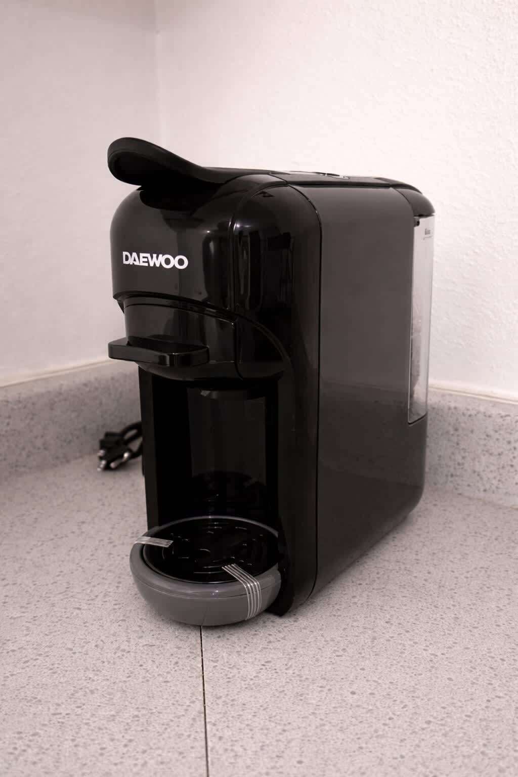 A black Daewoo coffee machine on a countertop.