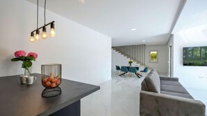 A modern living space with a kitchen area, dining area, and a staircase leading to an upper level. - Cozy home in Donji Prolozac (Donji Prolozac)