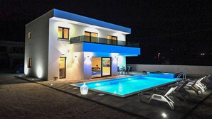 A modern two-story house with a swimming pool, outdoor seating, and a well-lit exterior. - Cozy home in Donji Prolozac (Donji Prolozac)