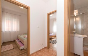 A bedroom with a bed, a bathroom with a sink, and a shower. - Gorgeous apartment in Rogoznica with WiFi (Rogoznica)
