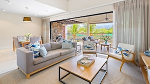 A spacious living area with a sofa, chairs, a coffee table, and a dining set. - La Balise Marina - Two Bedroom Apartment, Sleeps 4 (Rivière Noire)