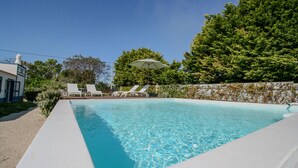 A swimming pool with clear water, surrounded by a white wall and greenery. - FLH Luz Tavira Al-Lagar II (Tavira)