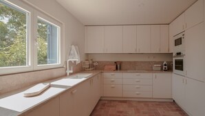 A kitchen with white cabinets, a window, a sink, and a microwave. - FLH Luz Tavira Al-Lagar II (Tavira)