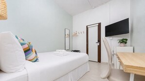 A modern hotel room with a bed, a desk, a chair, a TV, and a door. - San Juan Group Stay | 16 Rooms | Sleeps 32| Parking (San Juan)