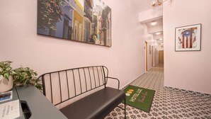 A hotel reception area with a bench, a desk, a potted plant, and a welcome mat. - San Juan Group Stay | 16 Rooms | Sleeps 32| Parking (San Juan)