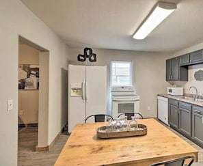 A compact kitchen with a refrigerator, stove, microwave, and sink.