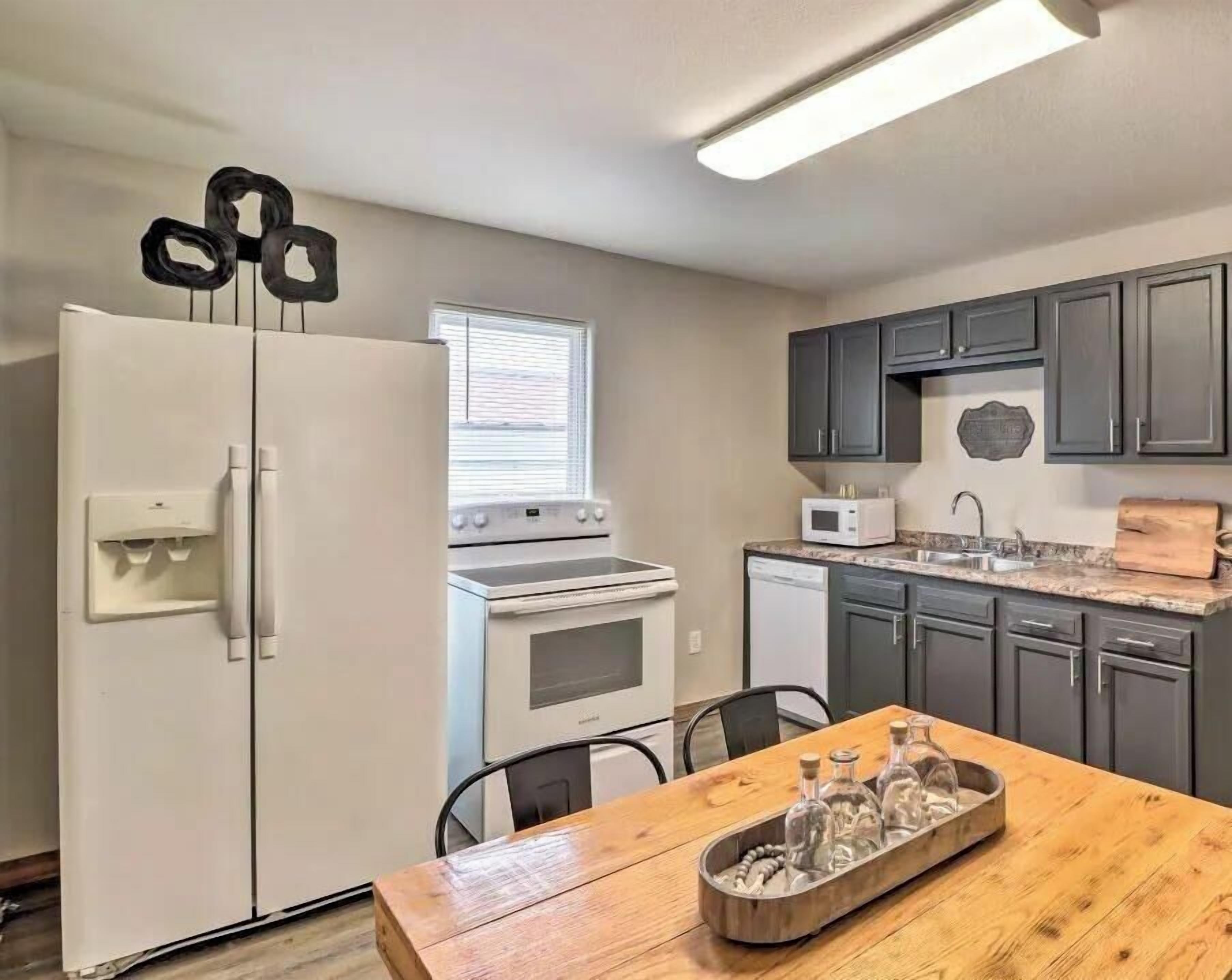 A kitchen with a refrigerator, stove, microwave, and cabinets.