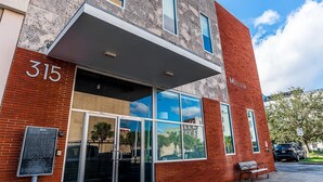 Un bâtiment à la façade en briques, doté de grandes fenêtres et d’une enseigne sur laquelle on peut lire « Meilleur ».
