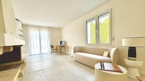 Una sala de estar moderna con un sofá, una mesa redonda de centro, una lámpara y un tablero de ajedrez.