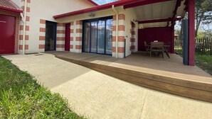 A two-story house with a covered patio, a garage, and a front door. - Air-conditioned house in the Arcachon style with swimming pool (La Teste-de-Buch)