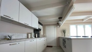 Una cocina moderna con armarios blancos, horno empotrado y una isla grande.