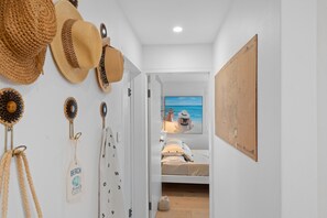 A bedroom with a bed, a wall-mounted artwork, and a door leading to another room. - Beachfront at Shoal Bay (Nelson Bay)