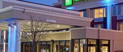 A Holiday Inn Express hotel with a modern facade, large windows, and a prominent entrance.