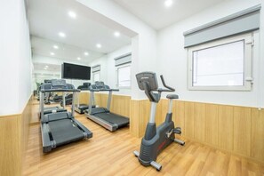 A gym with treadmills, an elliptical, and a stationary bike. - Holiday Inn Express Greater Noida Knowledge Park (Greater Noida)