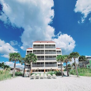 A multi-story hotel with a red roof, balconies, and a beachside location. - BEACH FRONT w/ ROOFTOP DECK! - {Aruba 6} Newly Renovated 2 BR / 2 BA - Walk to Times Square! (Fort Myers Beach)