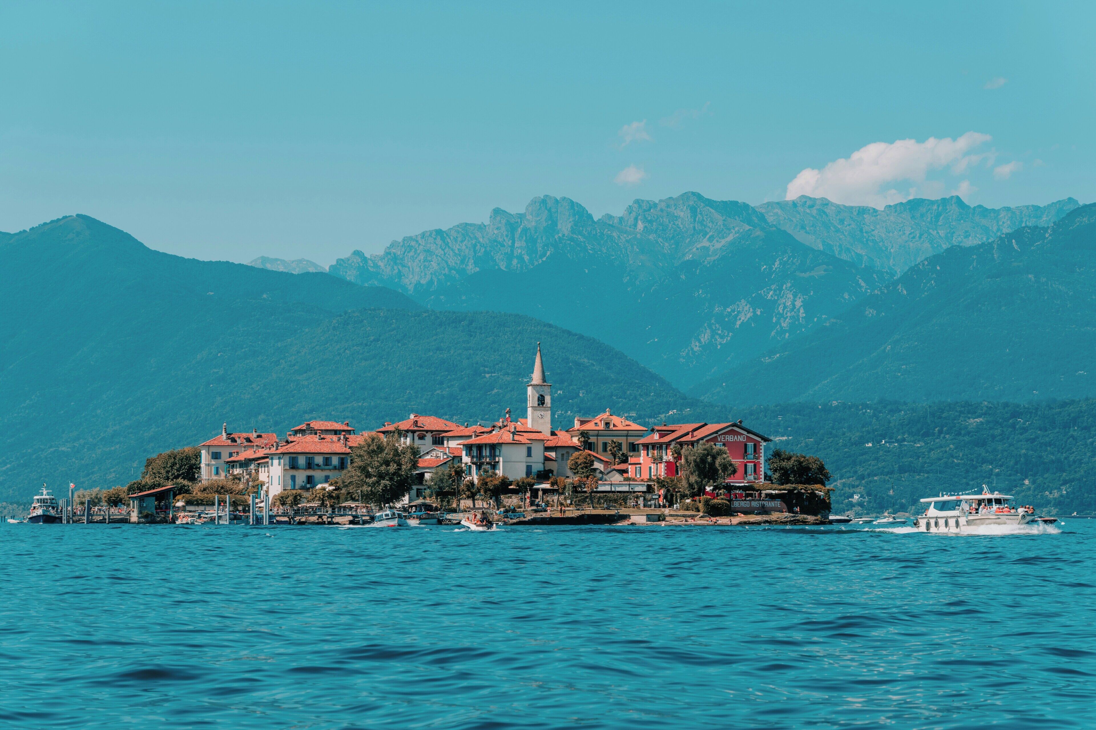 Eine Küstenstadt mit Häusern, einer Kirche und Booten auf dem Wasser.