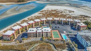 A coastal hotel with multiple buildings, a parking lot, and a beach view. - Inlet Point Villas 11D - Pool View (North Myrtle Beach)