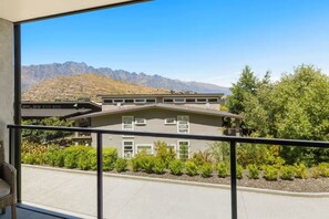 Un edificio con un balcone, vista sulle montagne e cielo sereno.