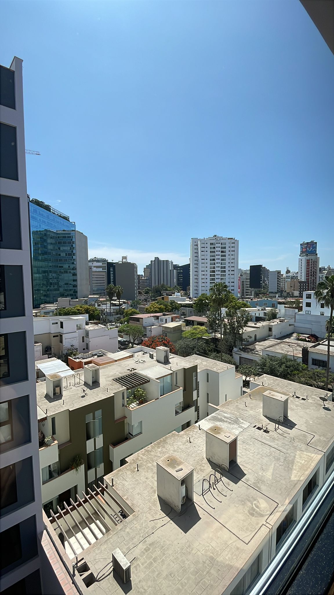 A high-rise building with multiple balconies and a clear view of the cityscape.