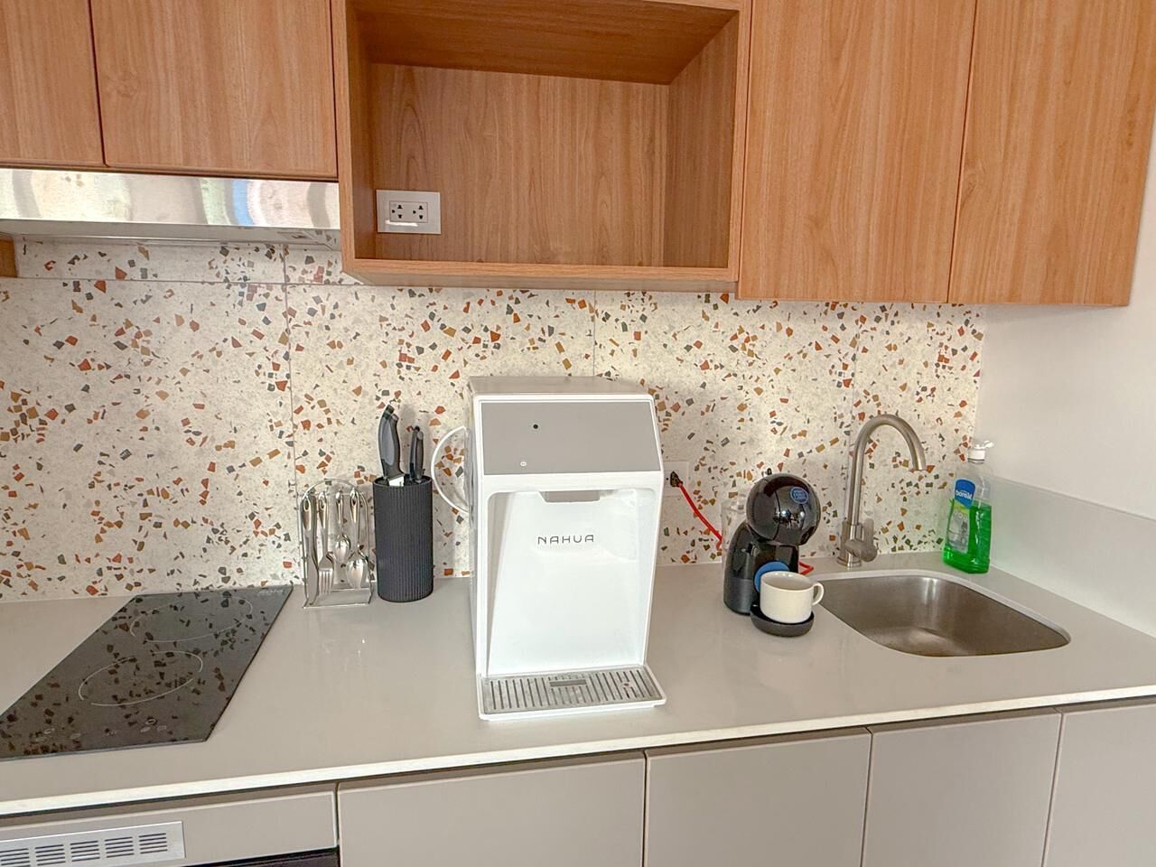 A kitchen with a coffee machine, sink, and countertop.