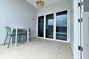 A balcony with a table and chairs, a sliding glass door, and a ceiling fan. - Santirome 2 - Quiet Caribbean Studio for Couples (Westpunt)