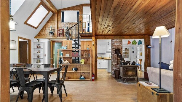 Amplio espacio tipo loft con comedor, cocina en altura y chimenea.