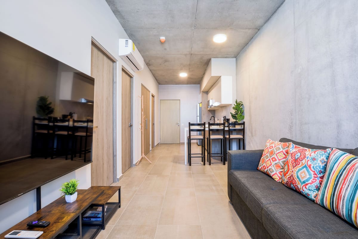 Una sala de estar moderna con un sofá, una mesa de centro y un comedor con sillas y una mesa.