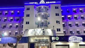 Un hotel de varios pisos con un letrero llamativo que dice 'HOTEL SIDI BRAHIM' y una entrada de 'RECEPTION'.