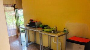 A compact kitchen with a sink, a small refrigerator, and a countertop.
