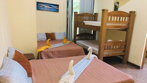 A room with two beds, a bunk bed, and a wooden chair.