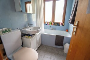 A bathroom with a toilet, sink, bathtub, and window with toiletries. - Arsets 61.11 3 rooms 2 bedrooms at the foot of the Gryon ski area - Villars - Les Diablerets (Gryon)