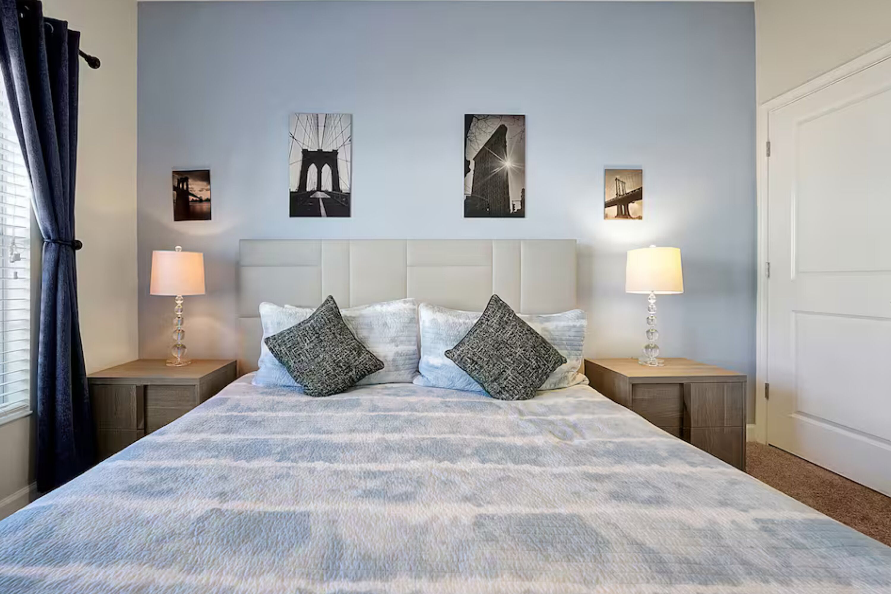 Une chambre à coucher comprenant un lit, deux tables de chevet, une tête de lit et des œuvres d’art murales.