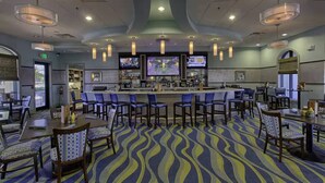 A hotel lobby with a bar area, seating arrangements, and a patterned carpet. - Private Pool 4BR Getaway in ChampionsGate (Four corners)