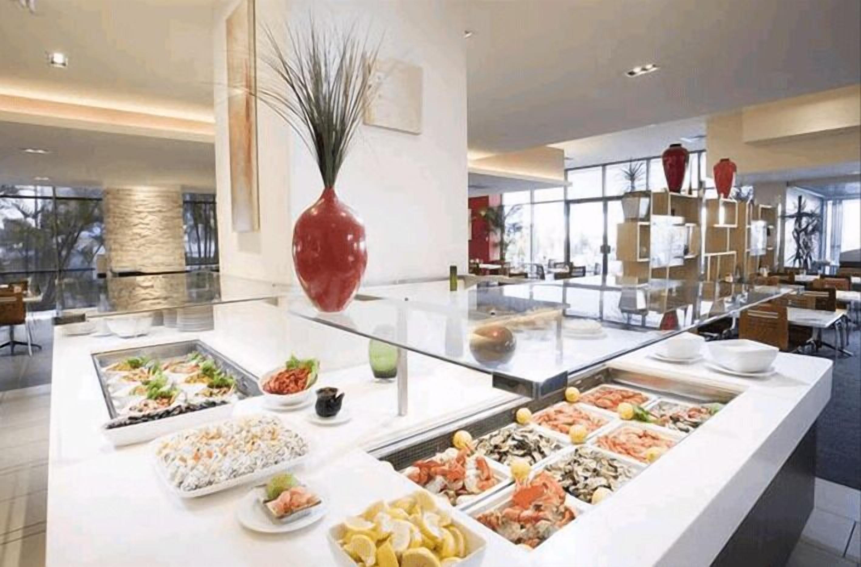 Un buffet proposant une variété de plats, un grand vase et un décor intérieur moderne.