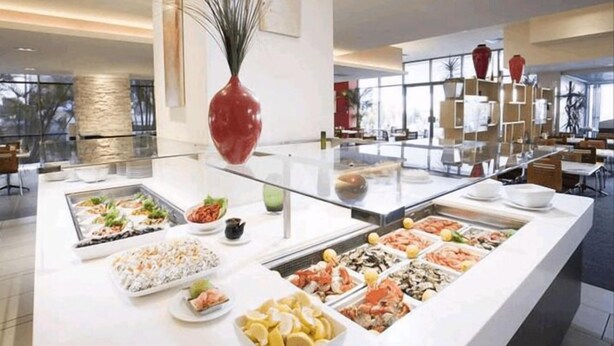 A buffet with various food options, a large vase, and a modern interior design. - View - 1627 (1BR/1BA) (Gold Coast)
