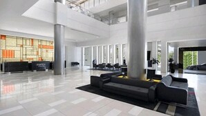 A spacious lobby with a reception desk, seating area, and large windows. - View - 1627 (1BR/1BA) (Gold Coast)