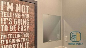 A framed motivational quote on a brick wall, a whiteboard, and a logo for Timber Valley. - West Plains 2BR Near Downtown Pet Friendly Stay (West Plains)