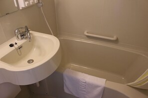 Une salle de bain avec un lavabo blanc, une baignoire et une serviette accrochée au mur.