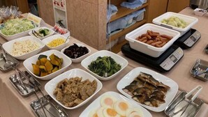 Une table de buffet proposant divers plats, notamment des légumes, de la viande et des œufs.