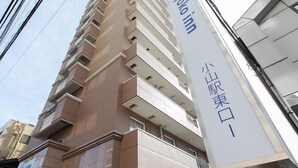 Un immeuble à plusieurs étages, sur lequel on peut lire une enseigne indiquant « Toyoko Inn » ainsi que des caractères chinois.