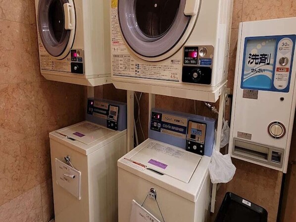 A laundry facility with multiple washing machines and a detergent dispenser. - Toyoko Inn Oyama Eki Higashi-guchi No.1 (Oyama)