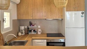 Une cuisine avec des meubles en bois, un réfrigérateur blanc, un lave-vaisselle et une machine à café.